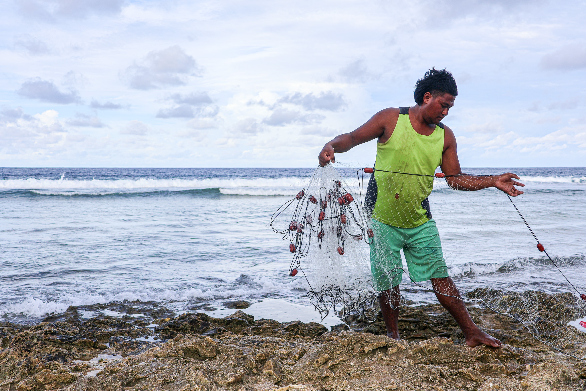 Tuvaluan fisherman preparing a cast net on the coastal reef